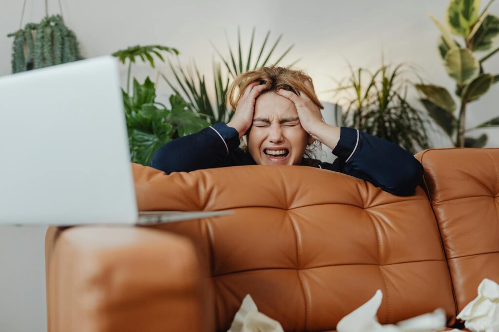 A person looking slightly frustrated while trying to set up smart home devices in a modern living room.