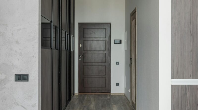A minimalist modern home entrance with a warm wooden door and clean architecture
