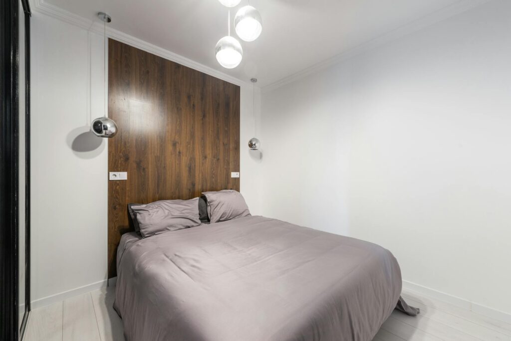 A cozy, modern bedroom with warm ambient lighting